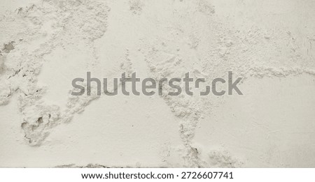 White wall paint background grumbling because it's been too long. Close up background of a white concrete cement wall that is cracked and the paint is peeling off. Old wall background wall with peelin