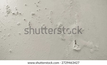 White wall paint background grumbling because it's been too long. Close up background of a white concrete cement wall that is cracked and the paint is peeling off. Old wall background wall with peelin