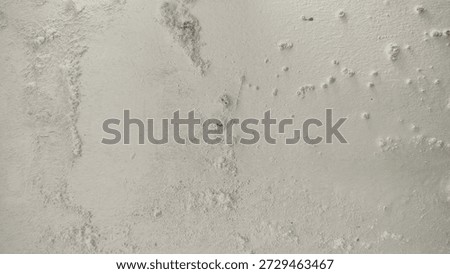 White wall paint background grumbling because it's been too long. Close up background of a white concrete cement wall that is cracked and the paint is peeling off. Old wall background wall with peelin