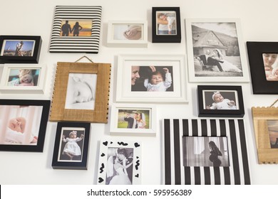 White Wall With Photos Of The Family In Various Photo Frames
