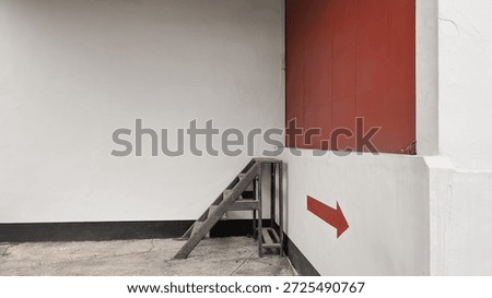 white wall with a red panel, small metal stairs, and a bold red right-pointing arrow on the lower wall, clean geometric composition, copy space on the left, modern urban architecture, direction and navigation concept.