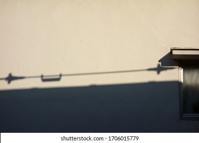 White Wall And Shadow Of Telephone Pole                             