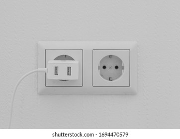 White Wall Socket With Plugged Charger.