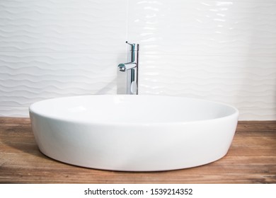 White washbasin and wooden stand