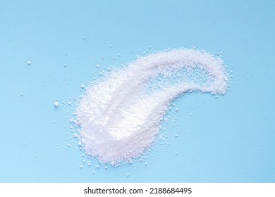 White washing powder pile on blue background