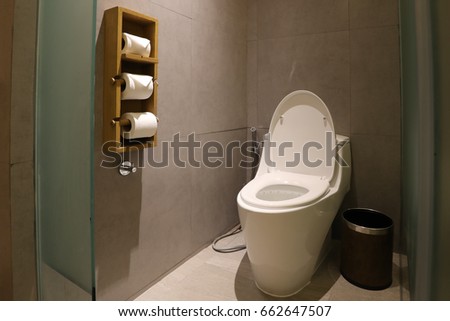 White water closet inside toilet room wall side hang with toilet paper
