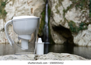 White Water Filtration Pitcher With Filter. Domestic Filter Jug On The Background Of A Mountain Lake