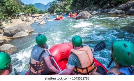 white water rafting with a team of green helmets in Thailand
