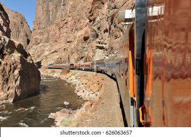 White Water River Flowing Through Colorado's Royal Gorge As A Train Rounds The Bend