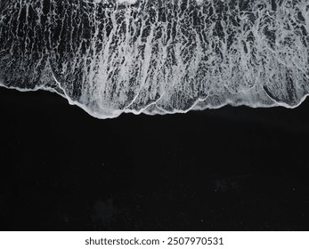 White waves on a black sand beach in a volcanic island in Iceland from a drone view - Powered by Shutterstock