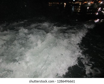 White Waves In Water Created From A Boat During Night.