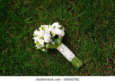 White Wedding Bouquet Lying On Green Grass