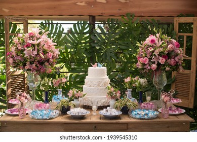 White wedding cake decorated by flowers and sweets