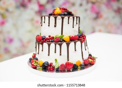 White wedding cake with flowers and leaves on black background isolated.