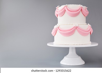 White Wedding Cake With Pink Elements Made From Pastry Mastic On A Gray Background. Sugar Flowers, Marzipan Flowers And Mastic, Beautiful Decor For Decorating Cakes.