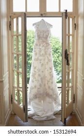 White Wedding Gown Hanging In Bridal Suite