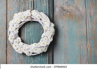 White wicker wreath of tiny chrysanthemums hanging on wooden door. Wedding decorations idea. Copy space - Powered by Shutterstock