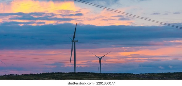 White Wind Turbines Installed In Scandinavian Tundra, Background Blue Sky Sunset Banner.