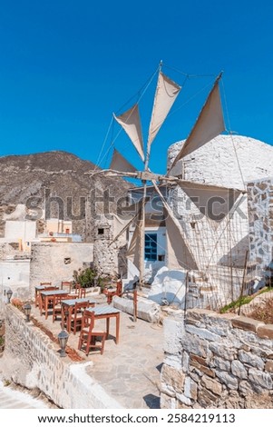 White windmill with open sails in Olympos village with sitting area in front on Karpathos island, Greece 