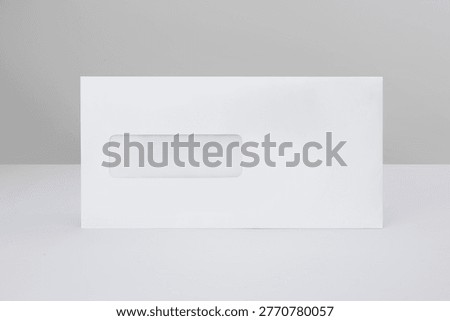 White window envelope mockup isolated on gray background. Minimalist stationary template is ideal for showcasing corporate identity designs, official mail, billing statements, and business correspondence.