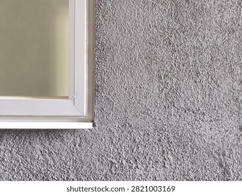 White window frame on gray textured stucco wall background