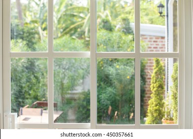 White Window House With Garden View In Daytime.