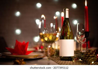 White Wine Bottle On A Christmas Holiday Festive Party Table With Wine A Glass On Red And Gold Shiny Decoration