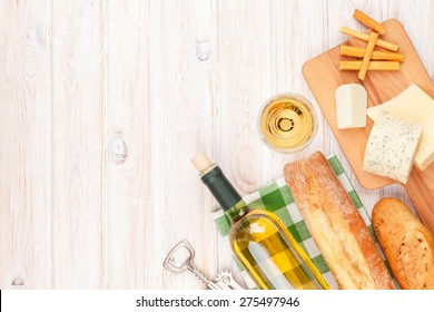 White Wine, Cheese And Bread On White Wooden Table Background. Top View With Copy Space