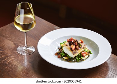 White wine and cod dish in restaurant - Shutterstock ID 2020005941