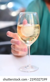 White Wine Glass With Ice And Human Hand Close Up Photo On Outdoor Cafe Background