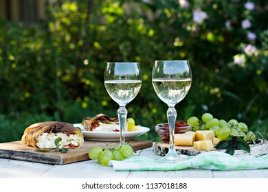 White wine and light snacks, Grapes, wine, cheese, pie. Summer romantic dinner in nature. Picnic. - Shutterstock ID 1137018188