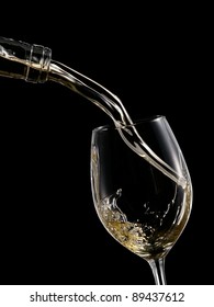 White Wine Pouring Into A Wineglass On Black Background