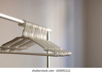 White Wire Hangers On An Empty Clothes Rack. Selective Focus. 