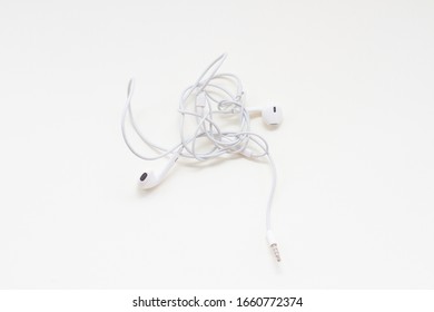 A White Wired Earbuds With Tangled Wires