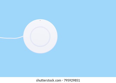 White wireless charger for mobile phone on blue background or isolated