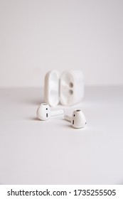 white wireless headphones with a case on a white background
