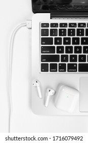 white wireless headphones and laptop
