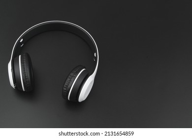 White wireless headphones on black background with copy space for text.