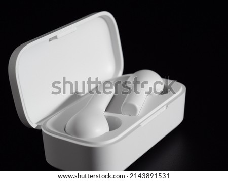 White wireless headphones on a black background