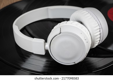 White Wireless Headphones On Old Vinyl Records. Music Concept. Rretro Sound System