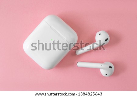 white wireless headphones on pink background. female headphones. copy space