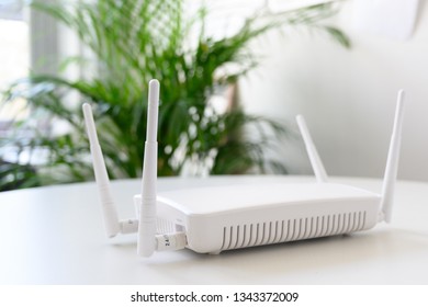 White Wireless Internet Router With Connection For Ethernet And Console On A Table In The Office, Copy Space, Selected Focus, Narrow Depth Of Field