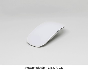 White wireless mouse on white background, minimal, flatlay.