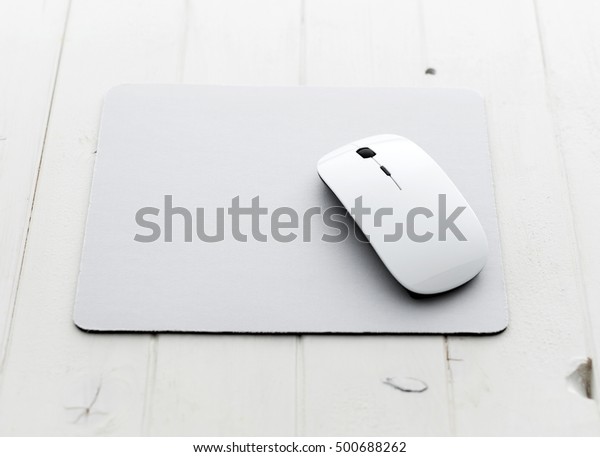 White wireless mouse on a\
mouse pad