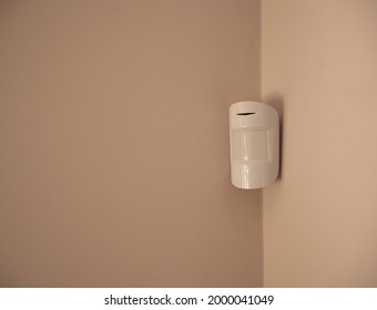 White wireless security sensor on a beige wall. Burglar alarm sensor. - Shutterstock ID 2000041049