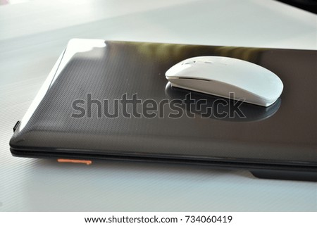 White wirless mouse put on laptop on white isolated 