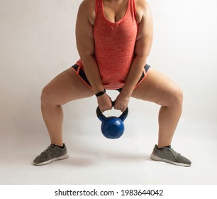 White Woman Performing Sumo Squat With Kettlebell On A White Background