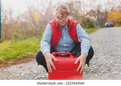 White Woman In Red Vest Holding Red Gasoline Container And Posing On Scenic Nature Country Road