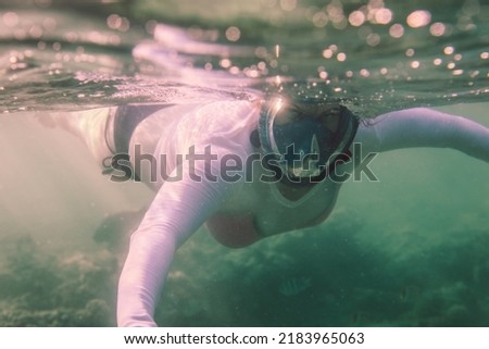White Woman Tourist diving Red Sea underwater with the Wild Sea Turtles near Marsa Alam, Egypt