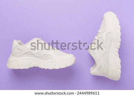 White woman trendy sneakers on color background, top view